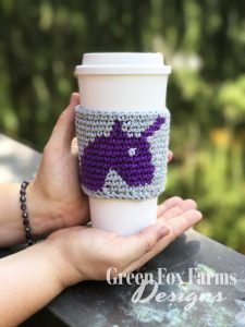 unicorn coffee cozy on cup held in hands
