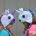 two girls wearing crochet unicorn hats