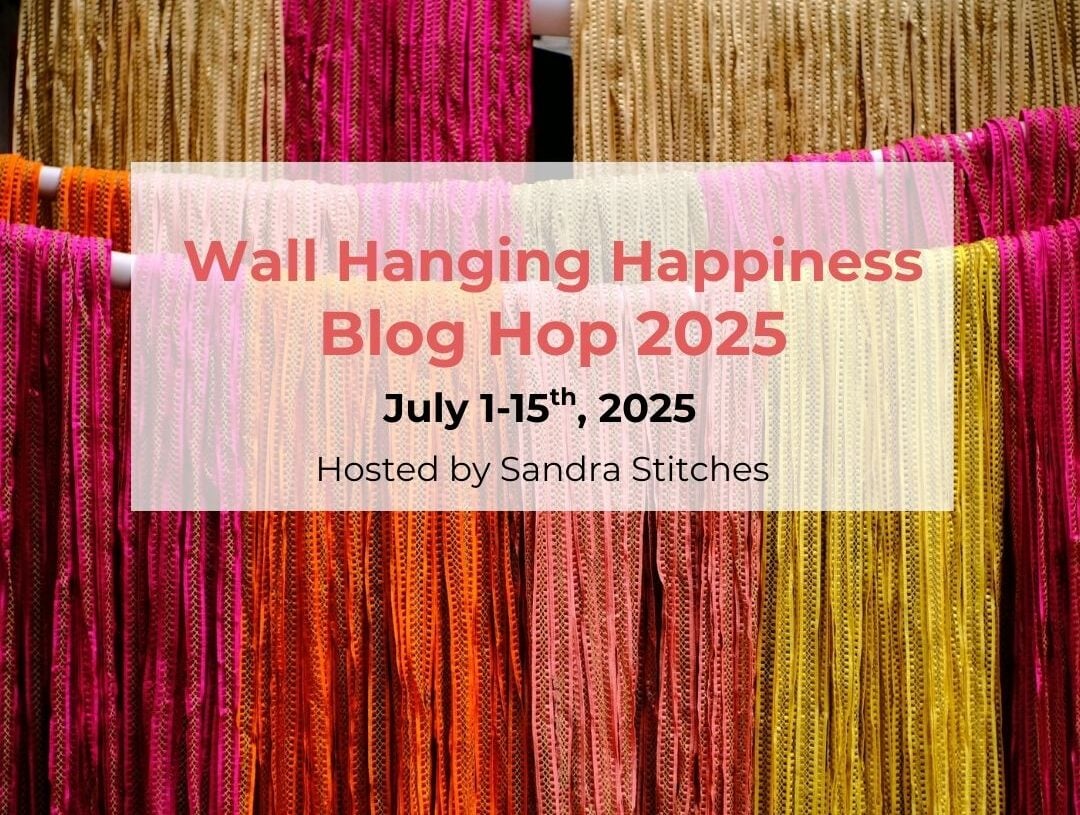 Friendship Blanket hanging from ladder in shades of purple, red, white, and pink by www.suflowercottagecrochet.com