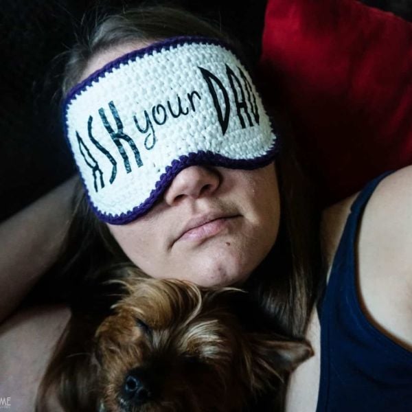 Woman wearing sleep mask laying down. Ask Your Dad Funny Crochet Sleep Mask Free Crochet Pattern