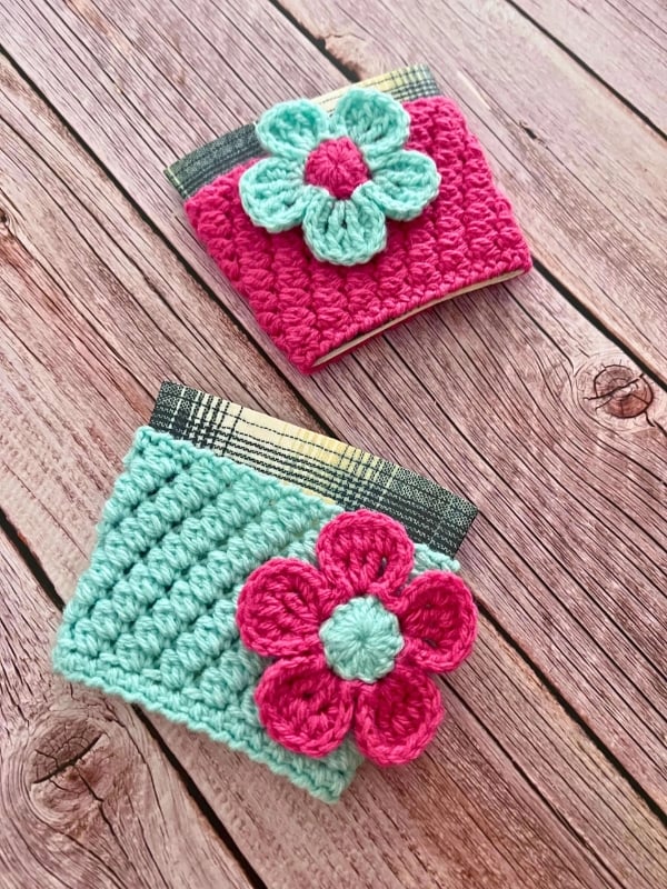 Colorful crochet cup cozies with flowers. Bean Lovers Cup Cozy Crochet Pattern by The Crochet Fix