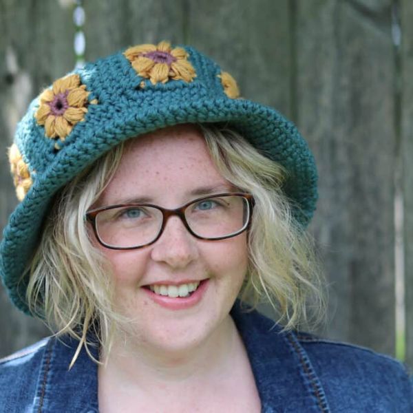 Smiling person wearing a crochet hat. Garden Bucket Hat Eco Friendy Crochet Pattern by Rich Textures Crochet