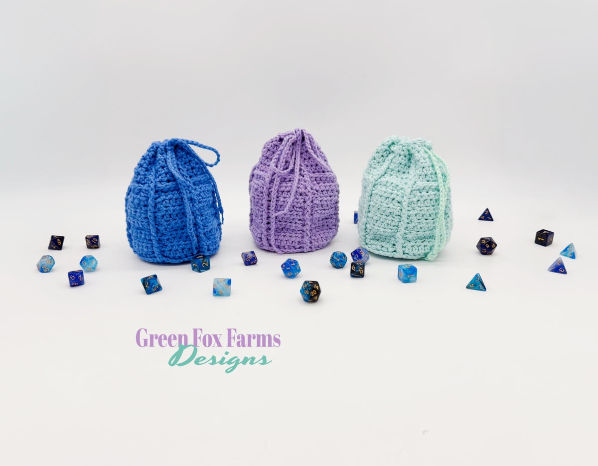 Linden Leaf Druid Dice Pouch Free Crochet Pattern shown in dark green and light green yarn with leaf detail hand stitched on the drawstring bags